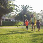 A joyful family enjoys a sunny day walking in a lush green park in Portugal.